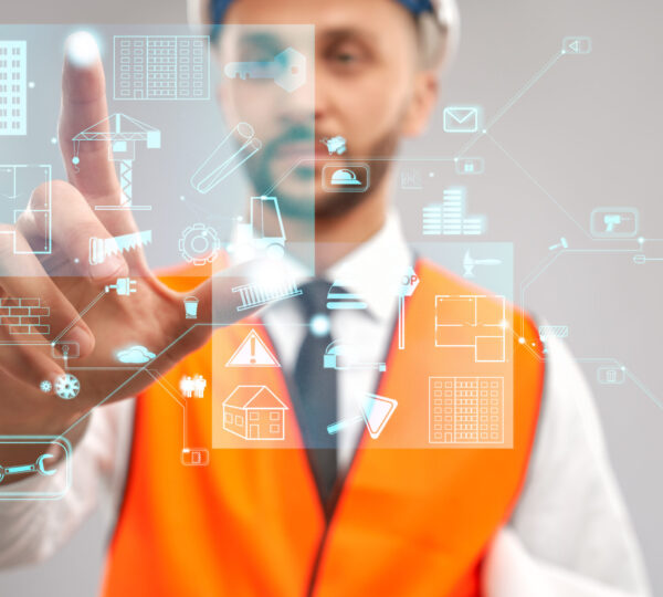 Close up of architect wearing reflective vest and helmet. Selective focus of digital tactile charts screen, man touching virtual icon on projection. Concept of digitalization, construction.
